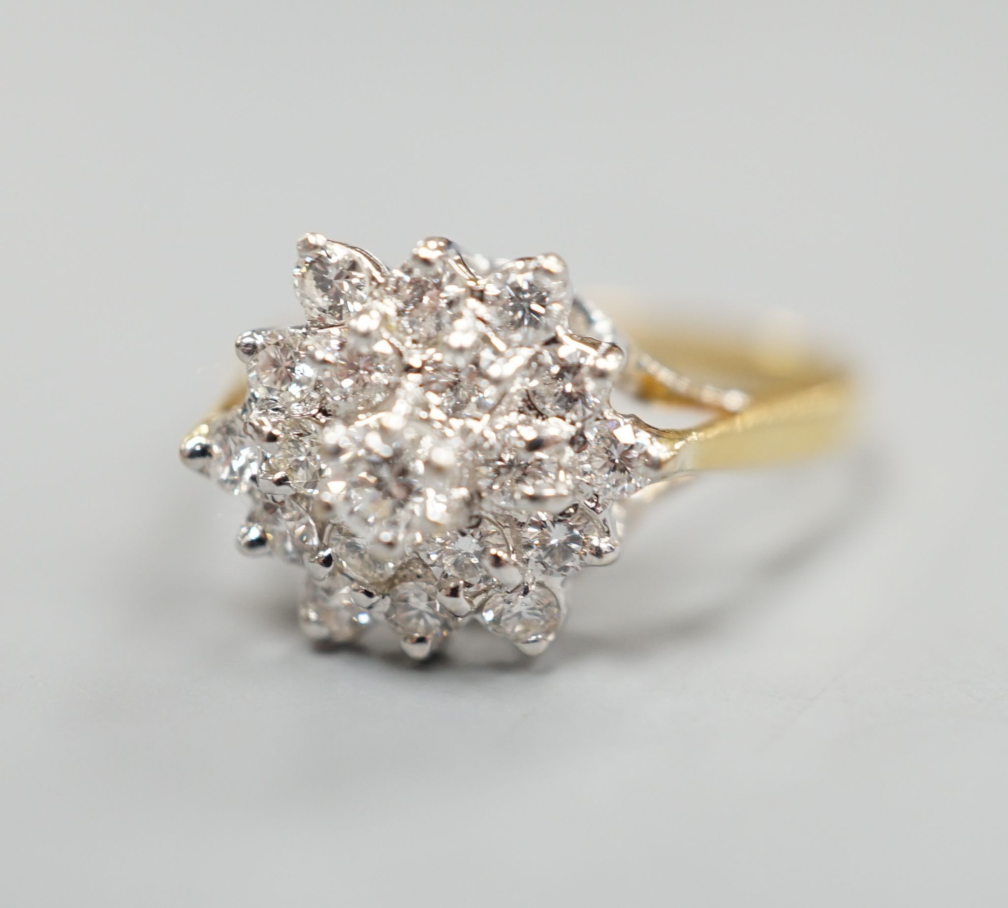 A modern 750 yellow metal and diamond set hexagonal cluster ring, size O, gross weight 3.4 grams.